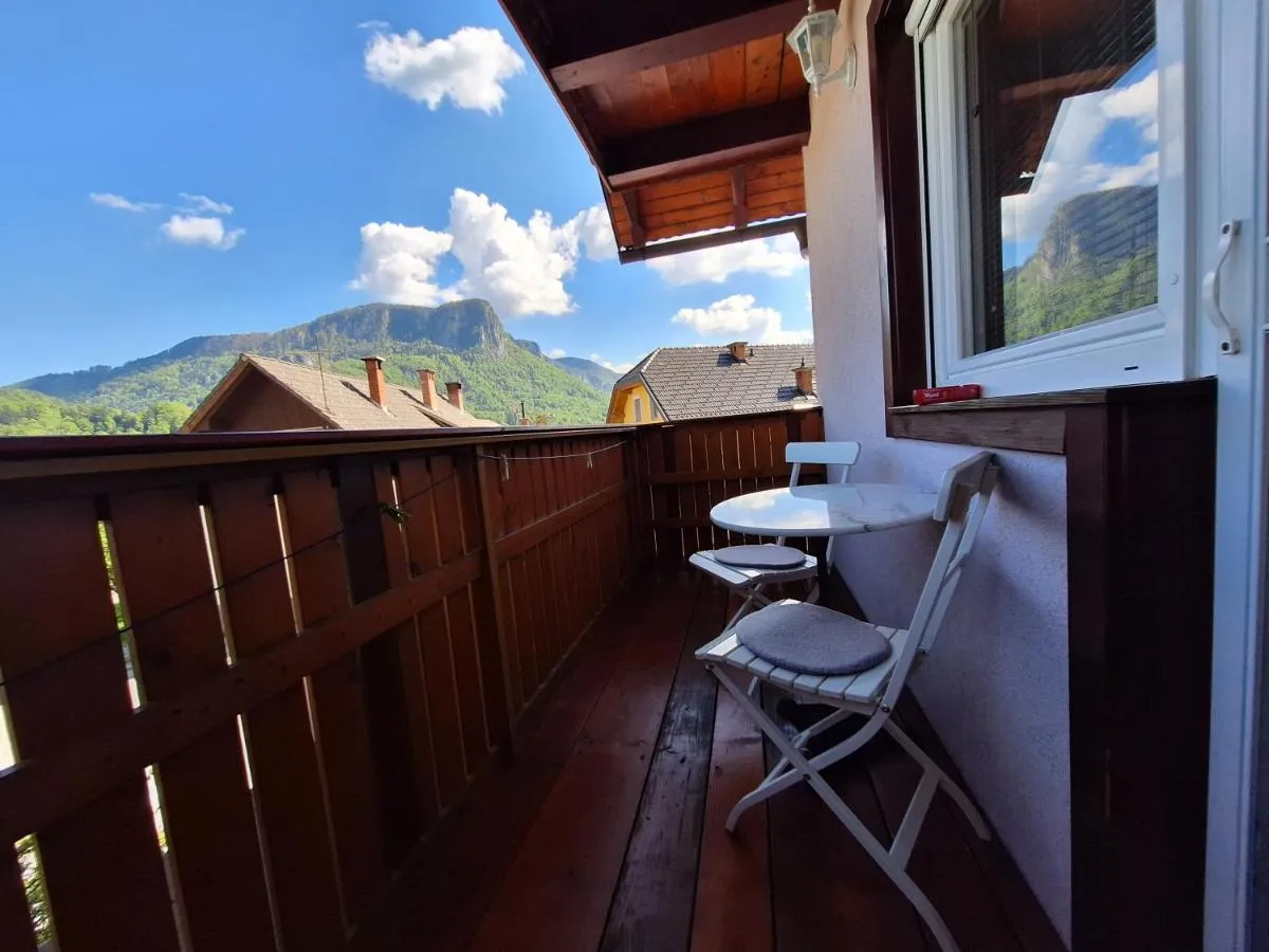 Balkon družinske sobe s stoloma in mizico, v ozadju gore